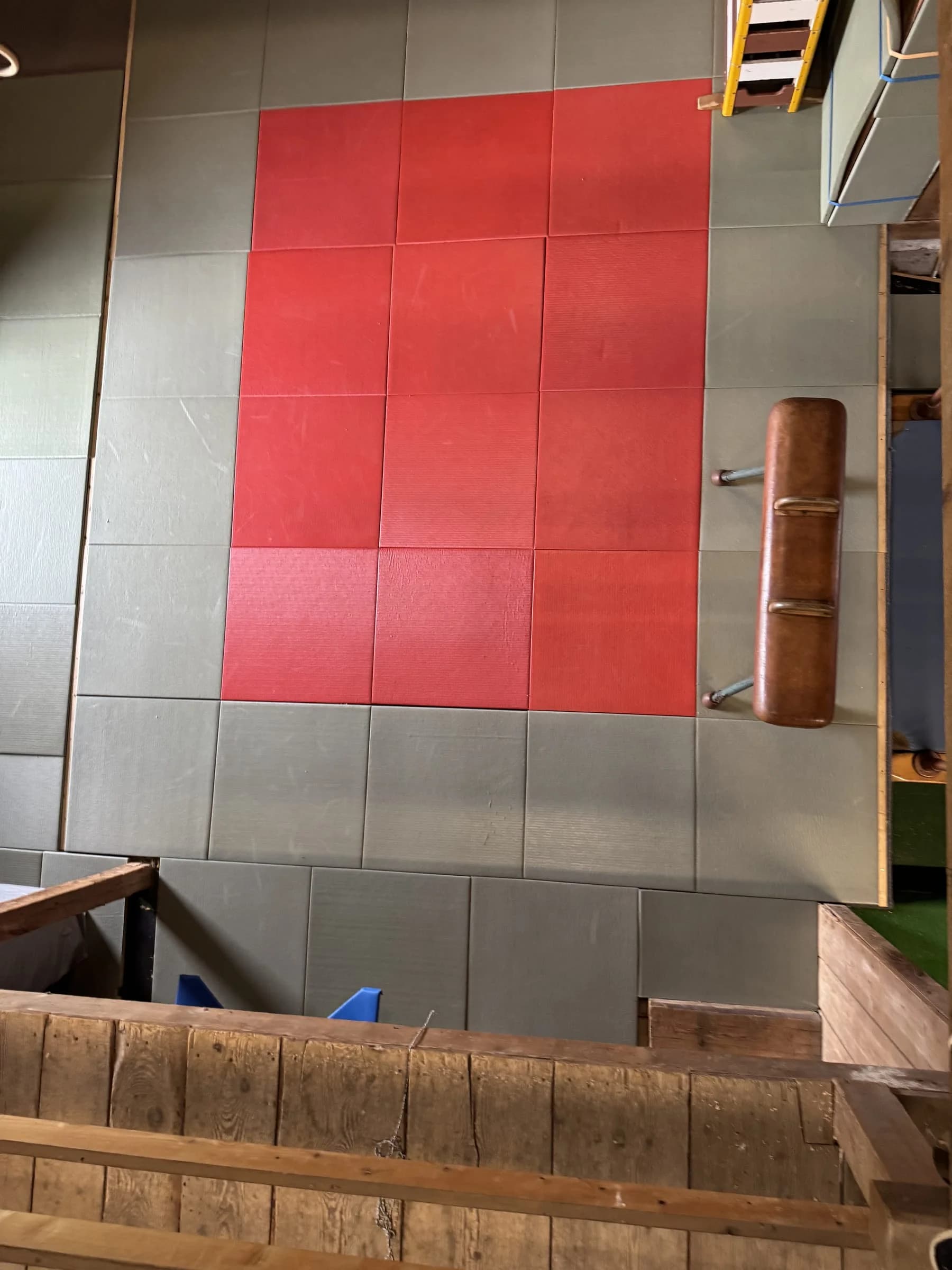 Blick von der Galerie hinunter auf die Mattenfläche mit rotem Feld und Pauschenpferd